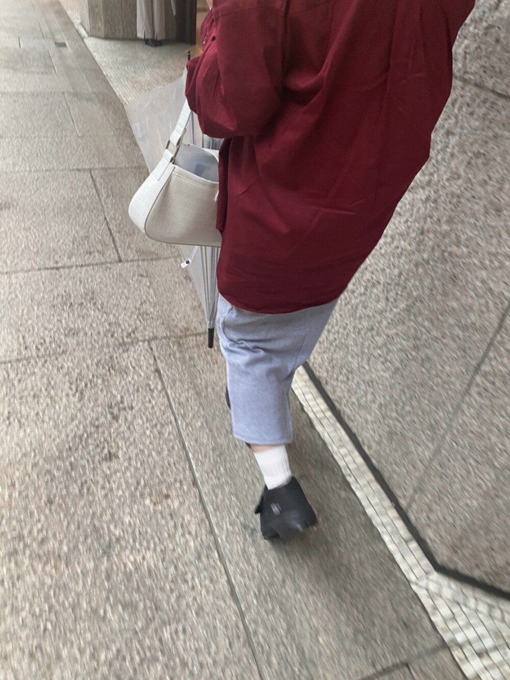 レッド系のシャツ/ブラウス、グレー系のワンピース、ホワイト系のショルダーバッグを着用したレディースの春コーディネートの2枚目の写真