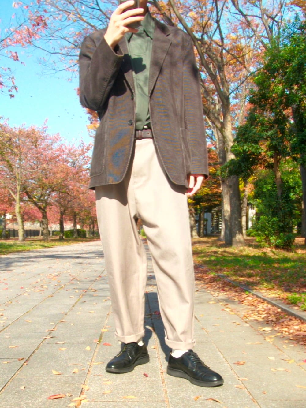 ブラウン系のテーラードジャケット、ベージュ系のスラックス、ブラック系のドレスシューズを着用したメンズの秋コーディネートの2枚目の写真