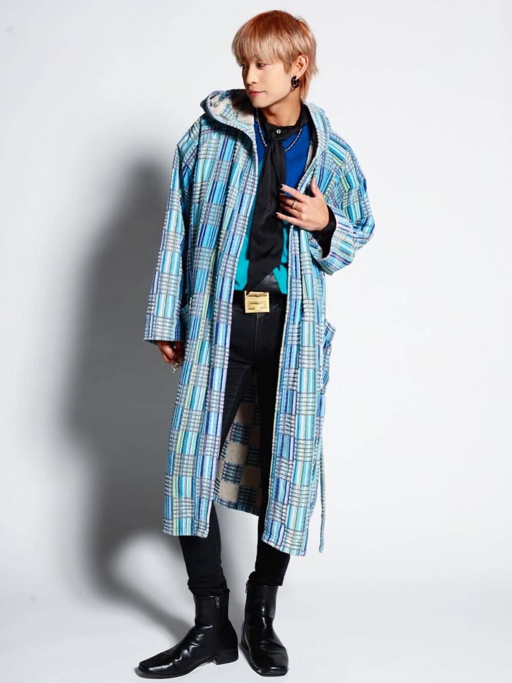 ブラック系のデニムパンツ、ブルー系のベスト、ゴールド系のベルトを着用したメンズの冬コーディネートの4枚目の写真