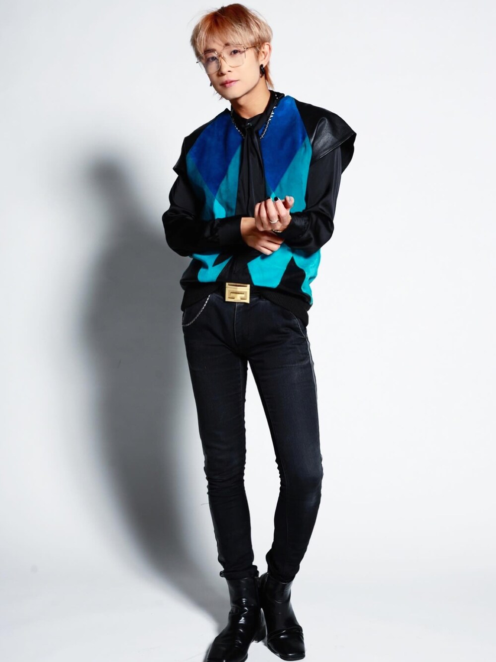 ブラック系のデニムパンツ、ブルー系のベスト、ゴールド系のベルトを着用したメンズの冬コーディネートの3枚目の写真