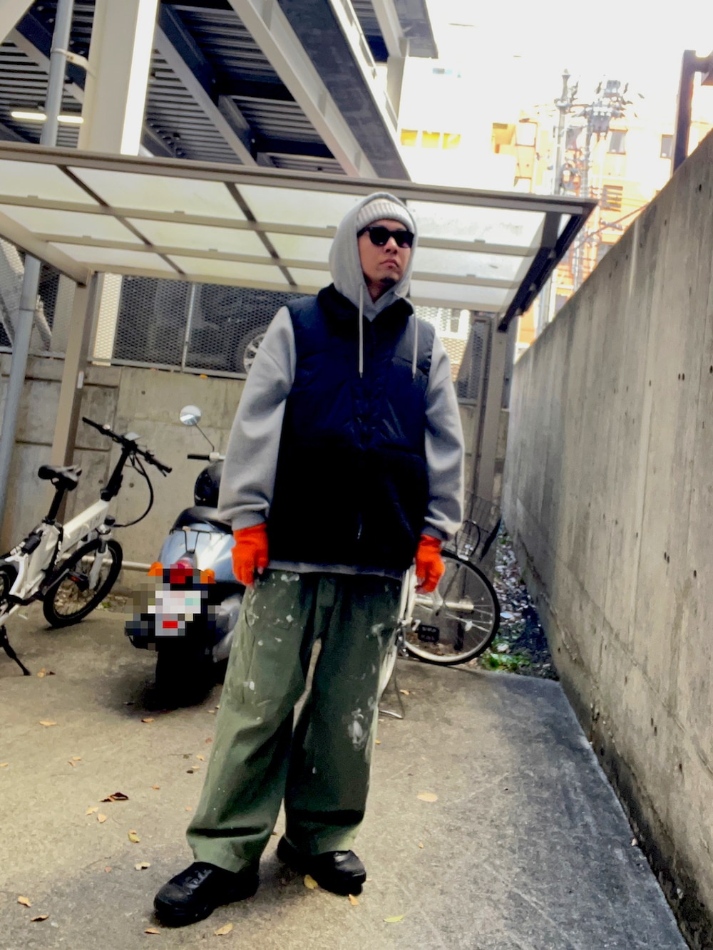 グレー系のパーカー、グリーン系のカーゴパンツ、ブラック系のスニーカーを着用したメンズの秋コーディネートの2枚目の写真