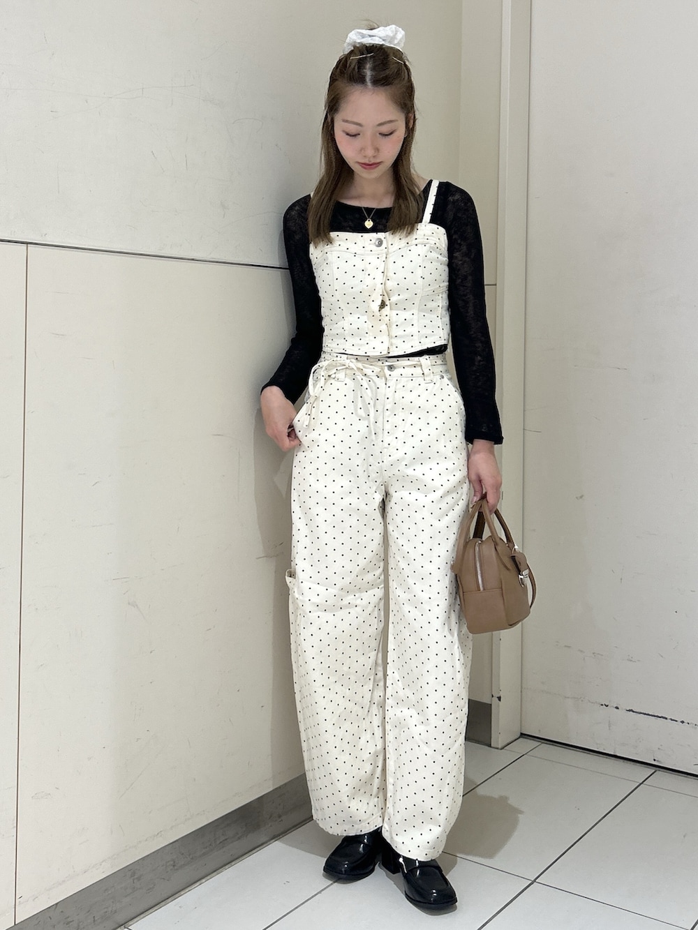 ホワイト系のデニムパンツ、ホワイト系のシャツ/ブラウス、ブラウン系のハンドバッグを着用したレディースの春コーディネートの2枚目の写真