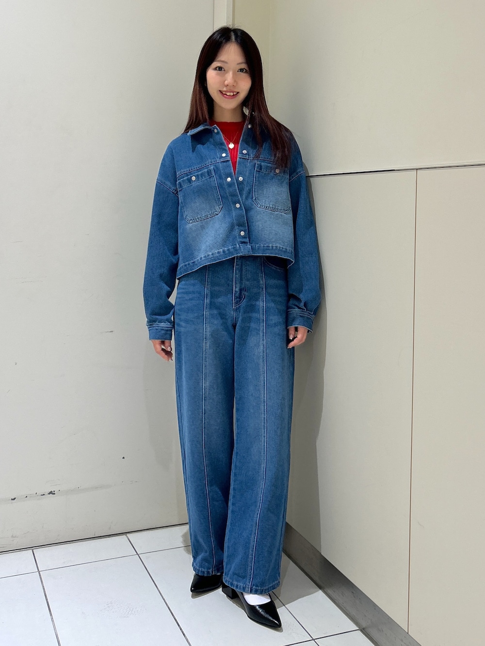 ブルー系のデニムパンツ、ブルー系のブルゾン、ホワイト系のトートバッグを着用したレディースの春コーディネートの3枚目の写真