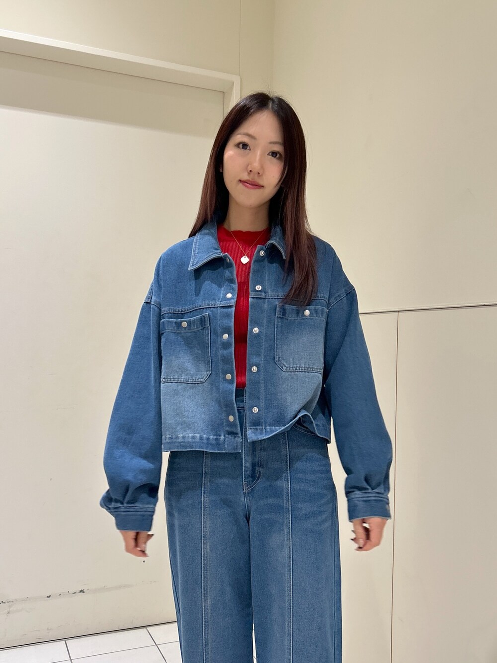 ブルー系のデニムパンツ、ブルー系のブルゾン、ホワイト系のトートバッグを着用したレディースの春コーディネートの5枚目の写真