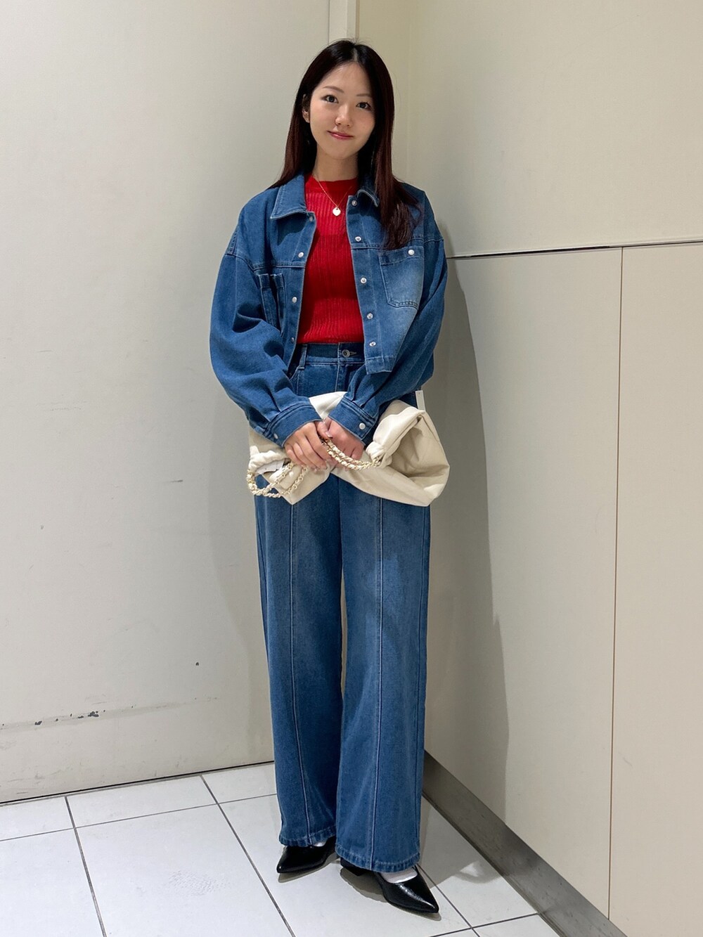 ブルー系のデニムパンツ、ブルー系のブルゾン、ホワイト系のトートバッグを着用したレディースの春コーディネートの2枚目の写真