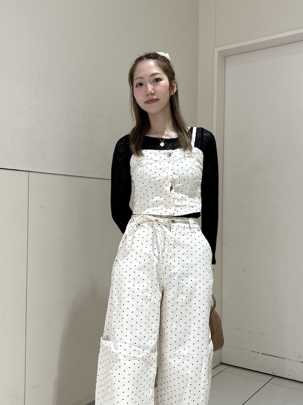 ホワイト系のデニムパンツ、ホワイト系のシャツ/ブラウス、ブラウン系のハンドバッグを着用したレディースの春コーディネートの5枚目の写真