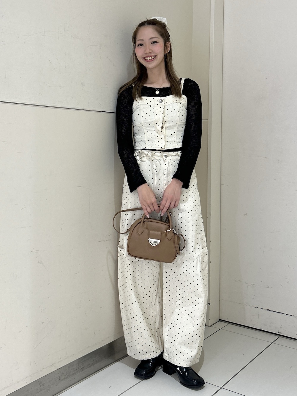 ホワイト系のデニムパンツ、ホワイト系のシャツ/ブラウス、ブラウン系のハンドバッグを着用したレディースの春コーディネートの3枚目の写真