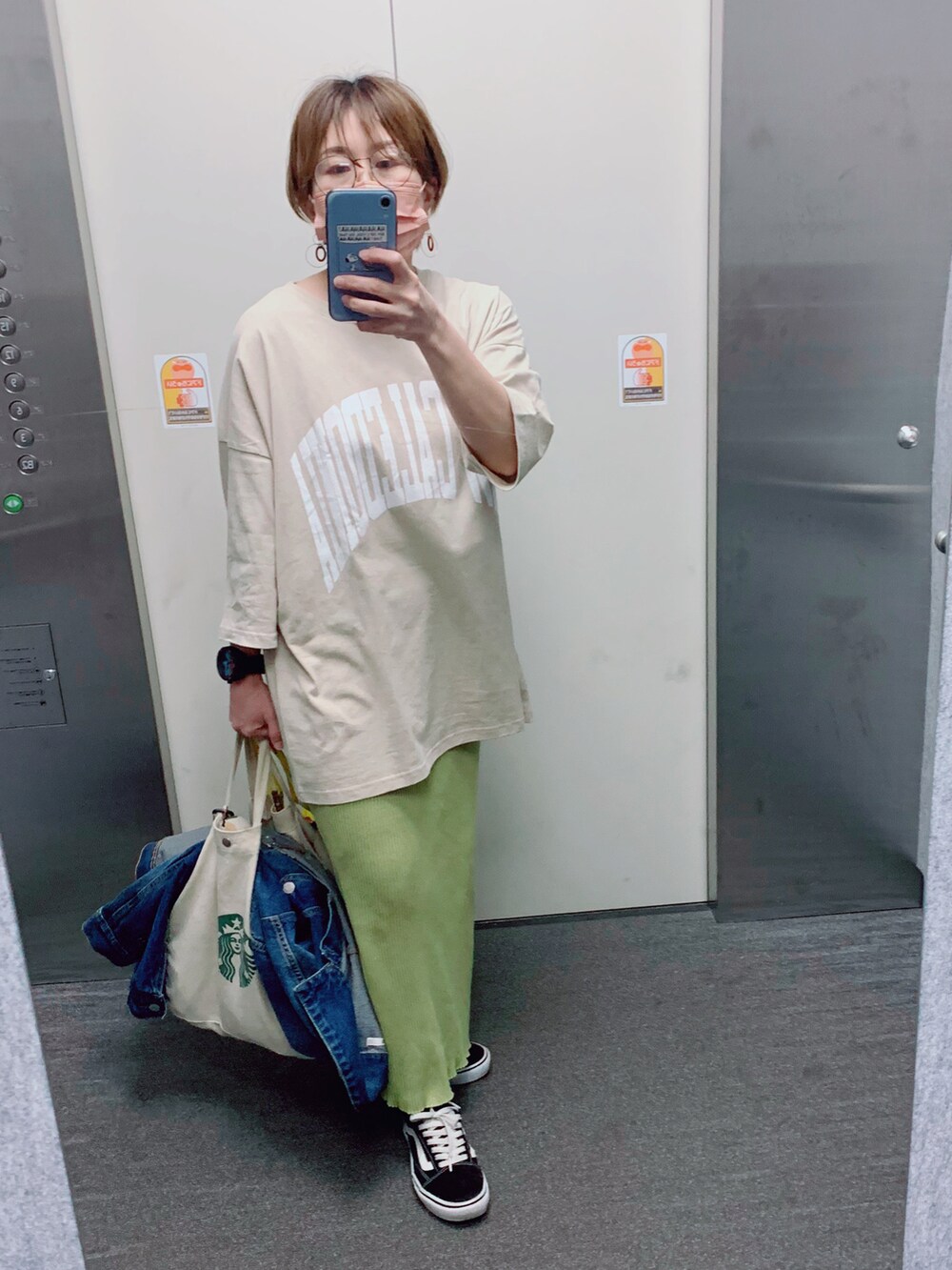 ベージュ系のTシャツ/カットソー、イエロー系のスカート、ブルー系のデニムジャケットを着用したレディースの春コーディネートの2枚目の写真