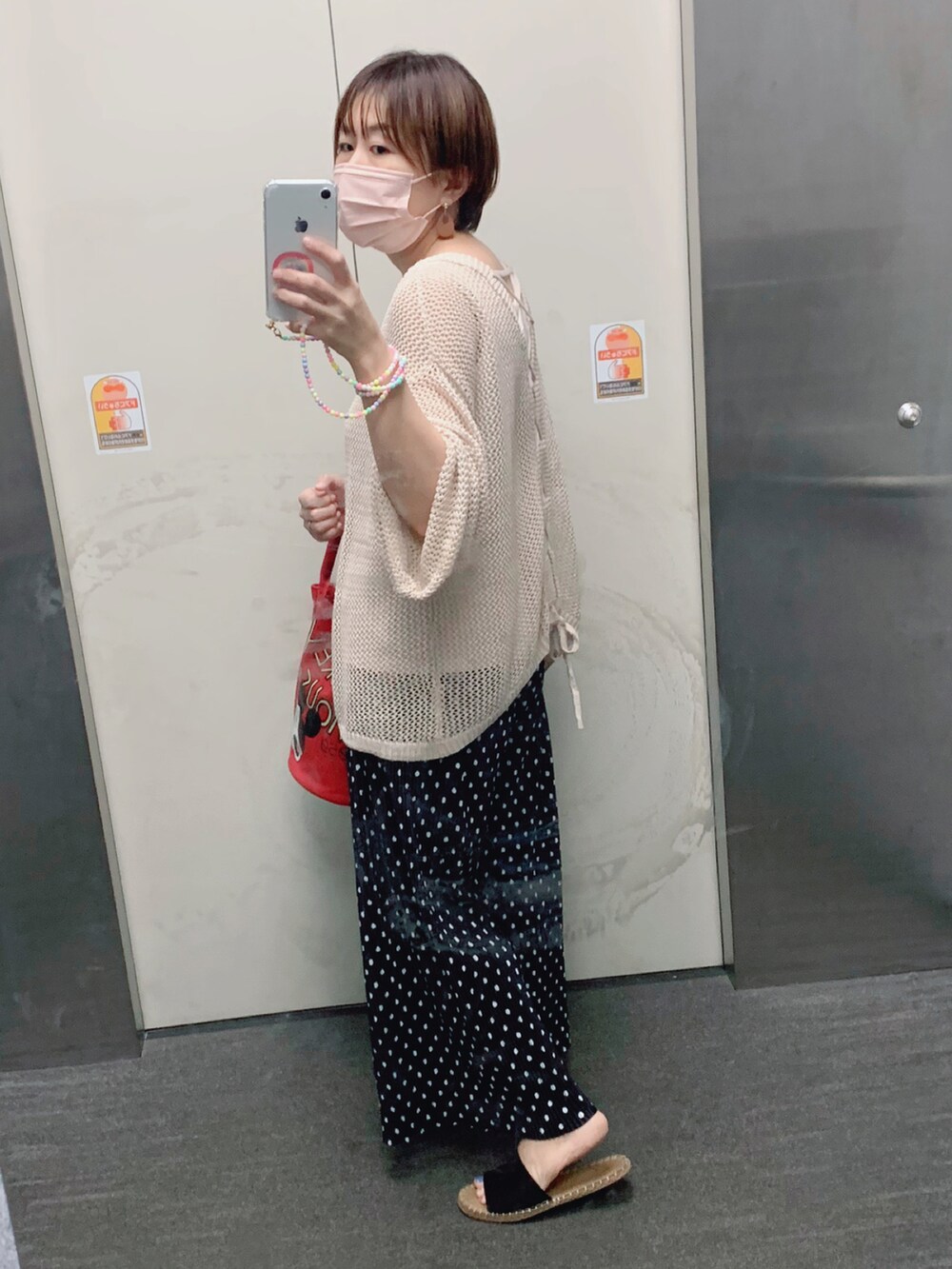 ホワイト系のニット/セーター、ブラック系のパンツ、ブラック系のサンダルを着用したレディースの夏コーディネートの2枚目の写真