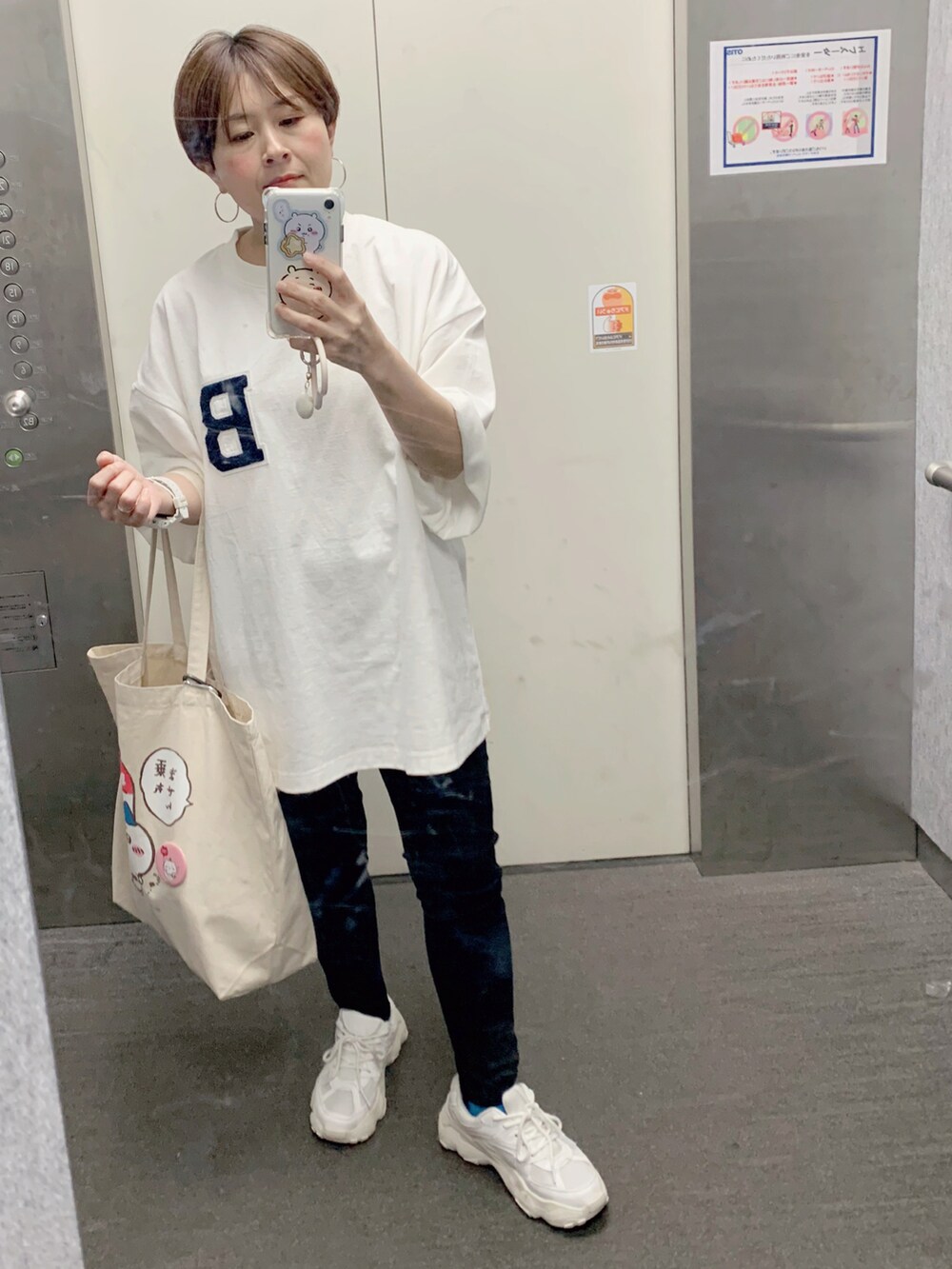 ホワイト系のトートバッグ、ホワイト系のTシャツ/カットソー、ブラック系のその他パンツを着用したレディースの春コーディネートの2枚目の写真