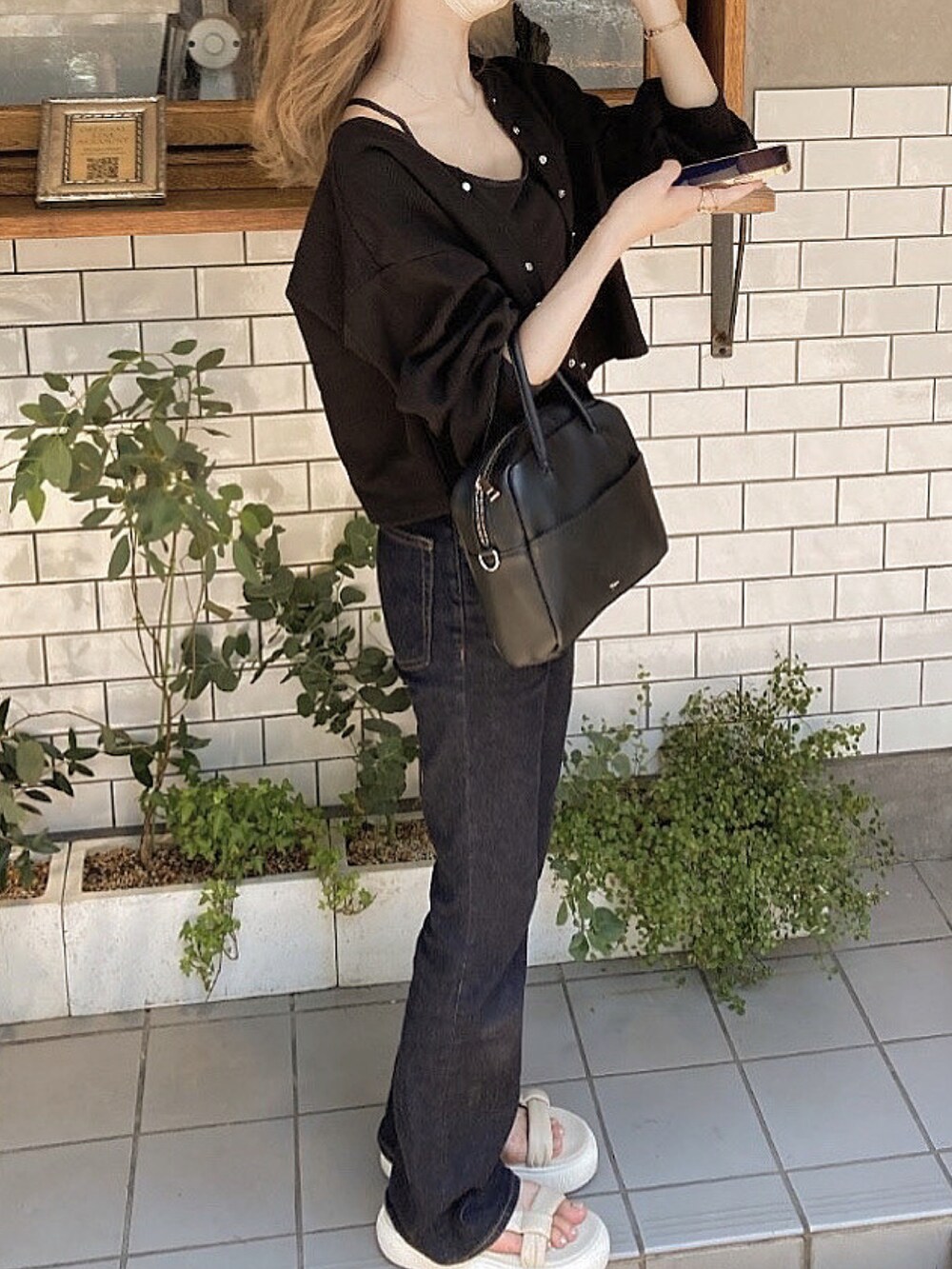 ブルー系のデニムパンツ、ホワイト系のサンダル、ブラック系のカーディガン/ボレロを着用したレディースの夏コーディネートの2枚目の写真