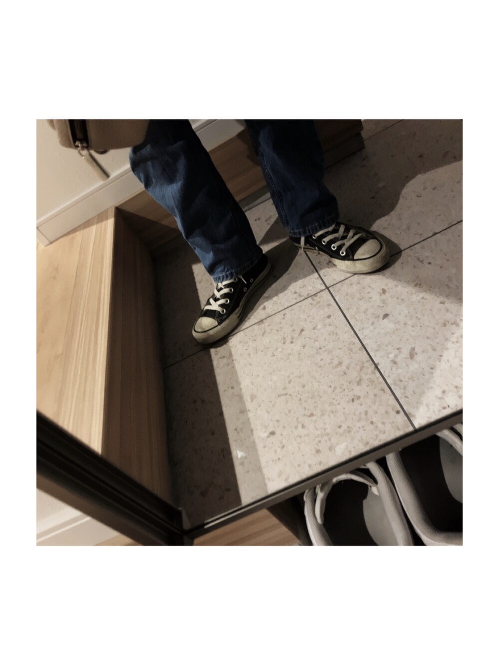 ブルー系のデニムパンツ、ブラック系のニット/セーター、ホワイト系のTシャツ/カットソーを着用したレディースの秋コーディネートの2枚目の写真