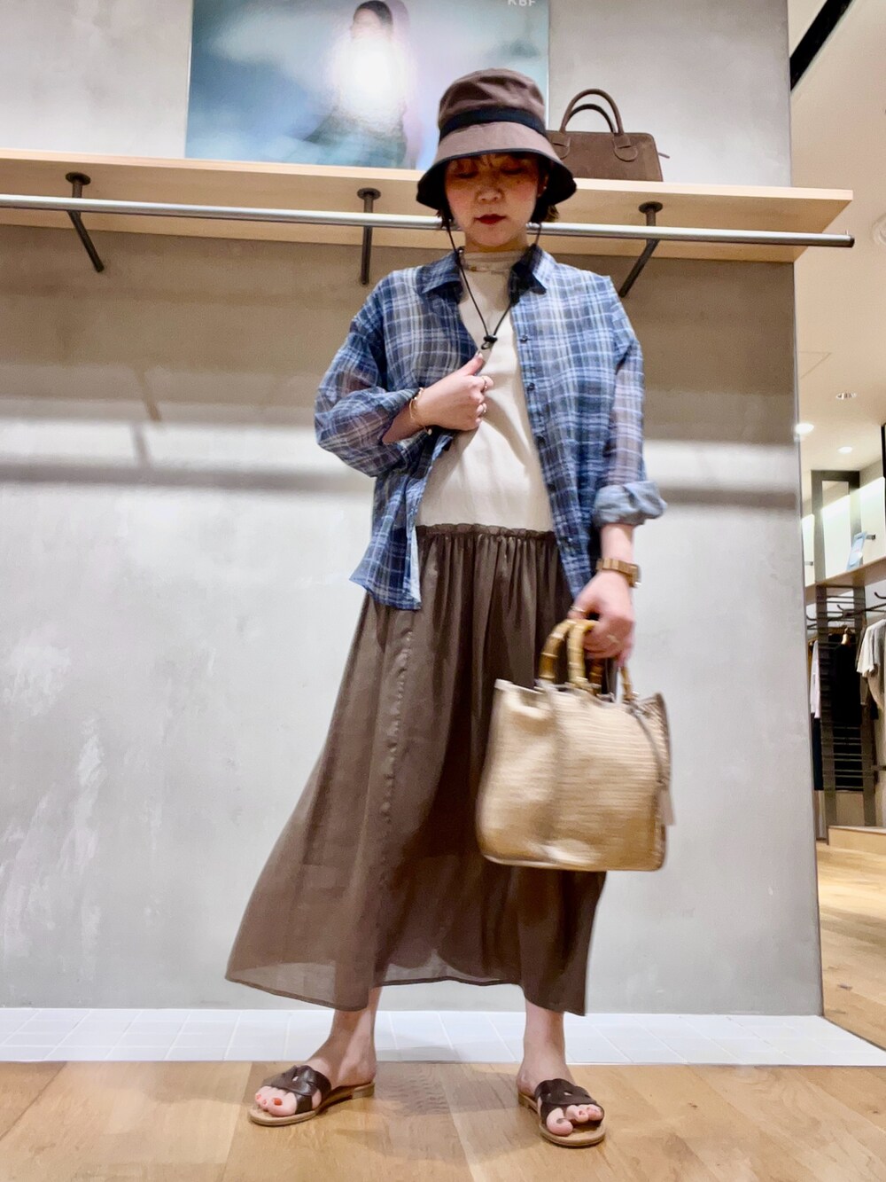 ブルー系のシャツ/ブラウス、ホワイト系のワンピース、ベージュ系のトートバッグを着用したレディースの夏コーディネートの2枚目の写真