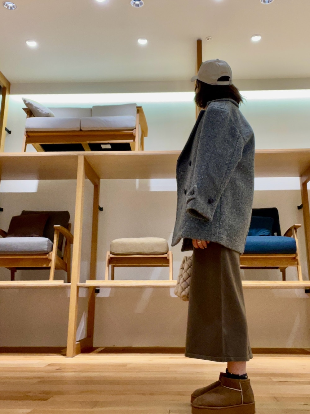 ホワイト系のハンドバッグ、グレー系のその他アウター、グリーン系のニット/セーターを着用したレディースの秋コーディネートの3枚目の写真