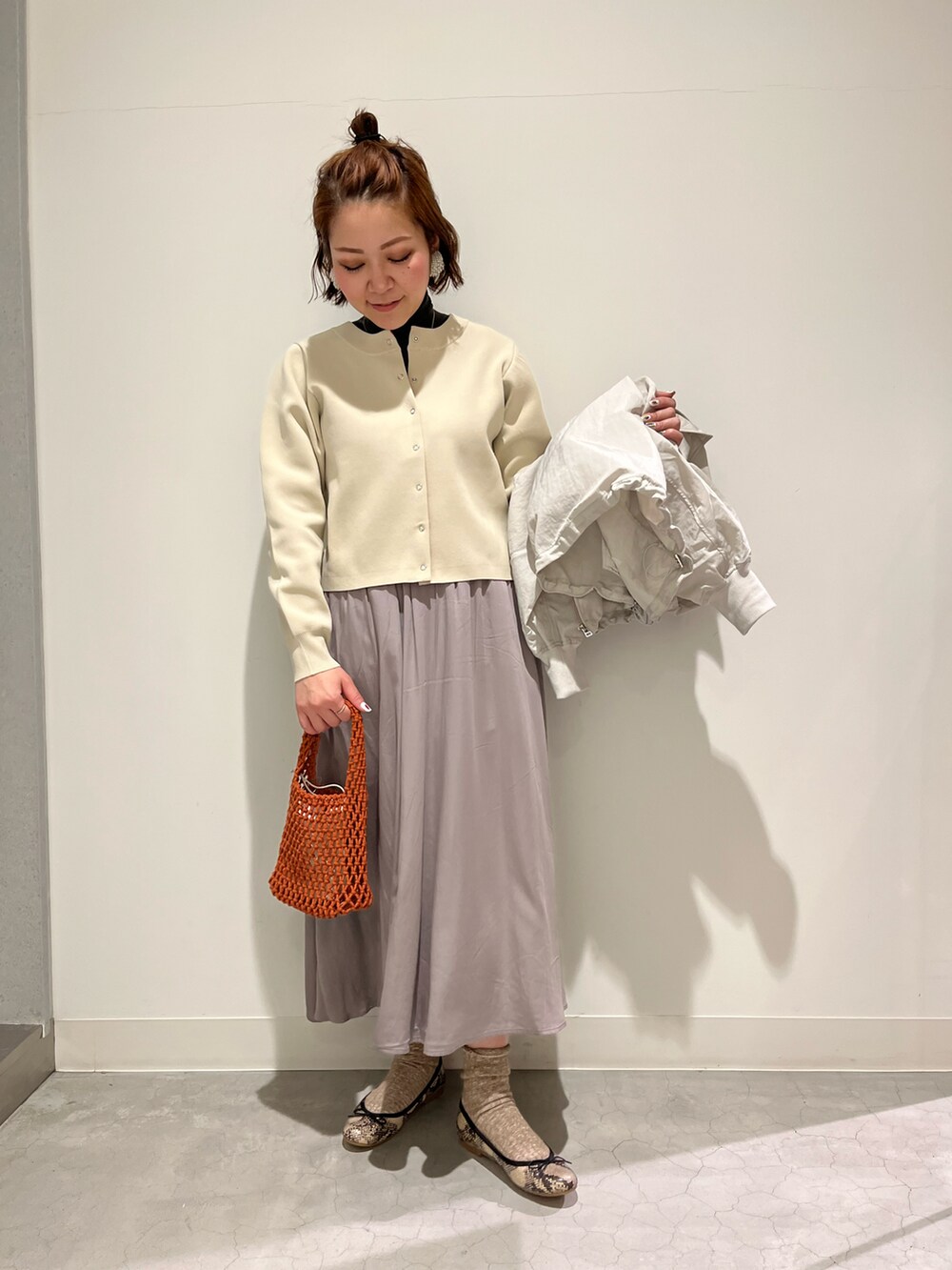 その他のシューズ、グレー系のスカート、オレンジ系のトートバッグを着用したレディースの春コーディネートの3枚目の写真