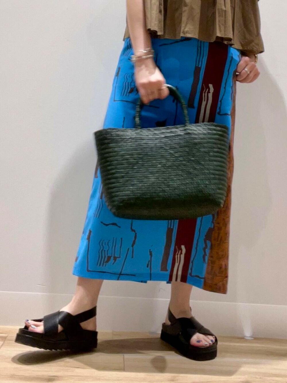 グリーン系のトートバッグ、ブラック系のタンクトップ、ブラック系のサンダルを着用したレディースの夏コーディネートの5枚目の写真