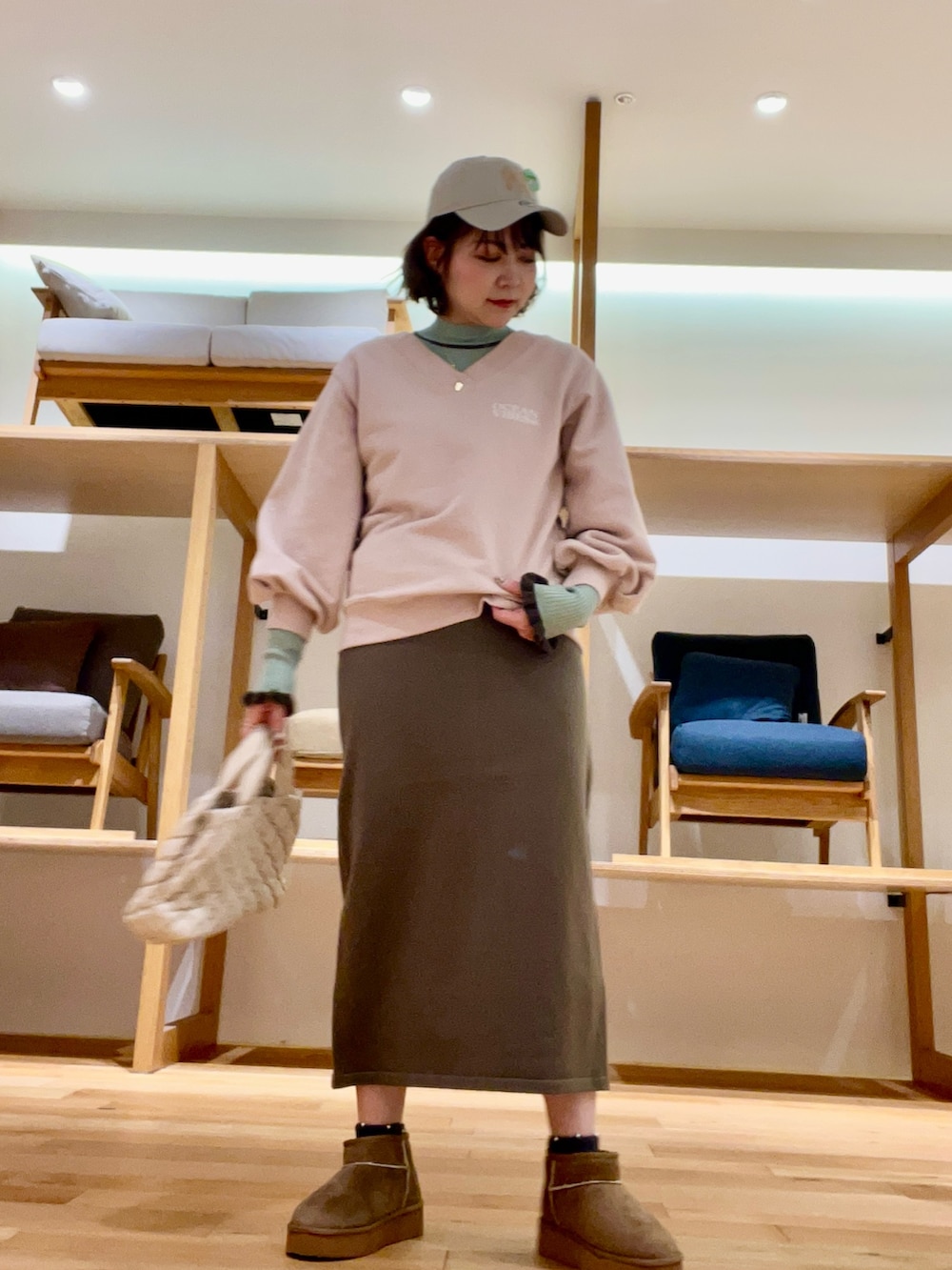 ホワイト系のハンドバッグ、グレー系のその他アウター、グリーン系のニット/セーターを着用したレディースの秋コーディネートの5枚目の写真