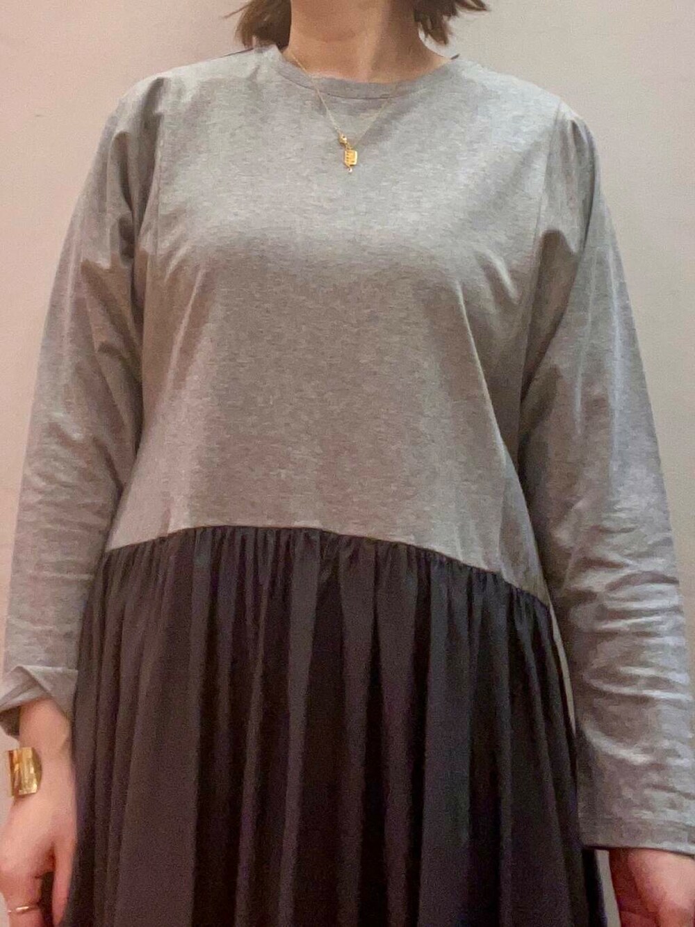 ベージュ系のステンカラーコート、シルバー系のブーツ、グレー系のワンピースを着用したレディースの冬コーディネートの9枚目の写真