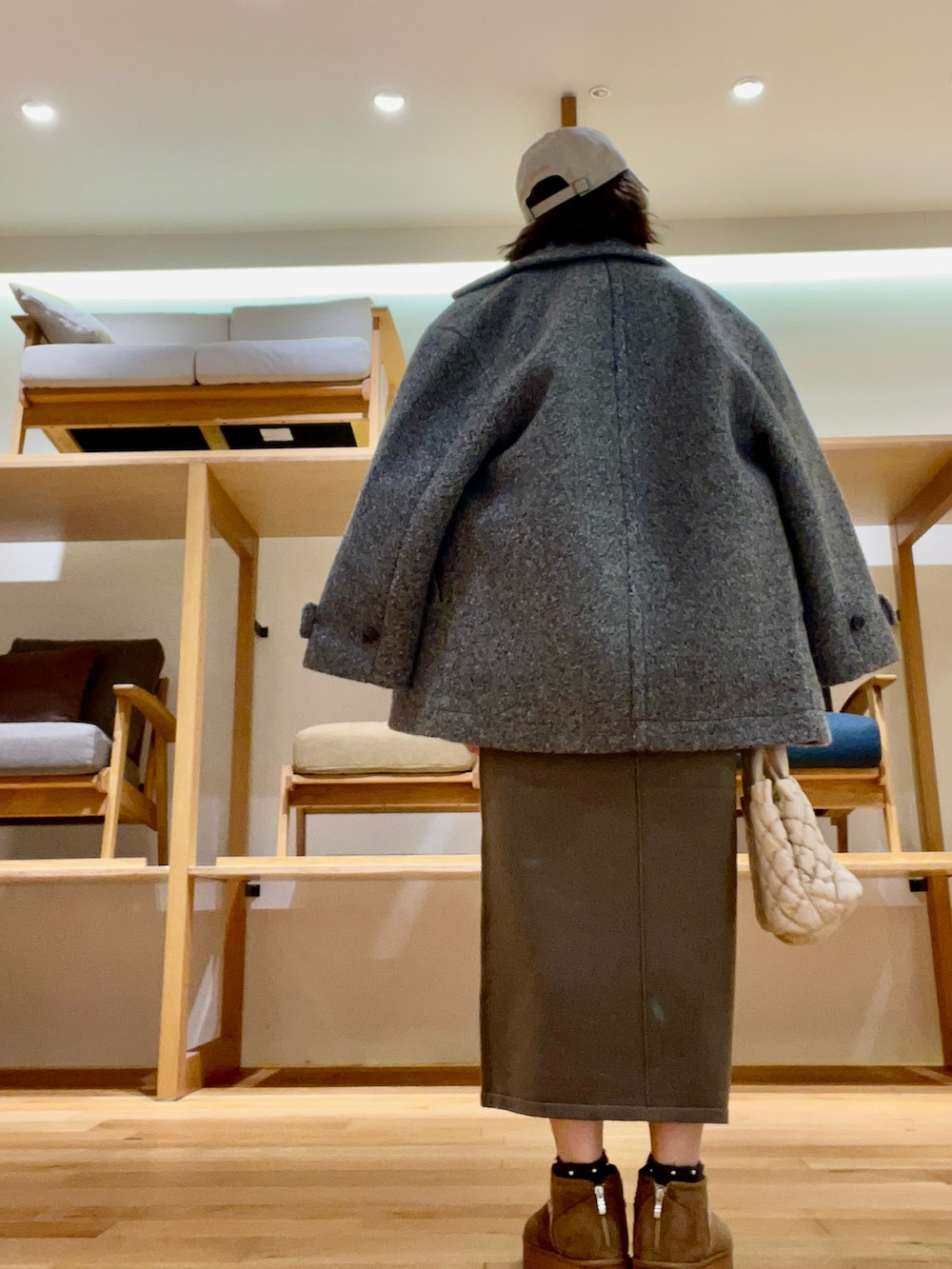 ホワイト系のハンドバッグ、グレー系のその他アウター、グリーン系のニット/セーターを着用したレディースの秋コーディネートの4枚目の写真