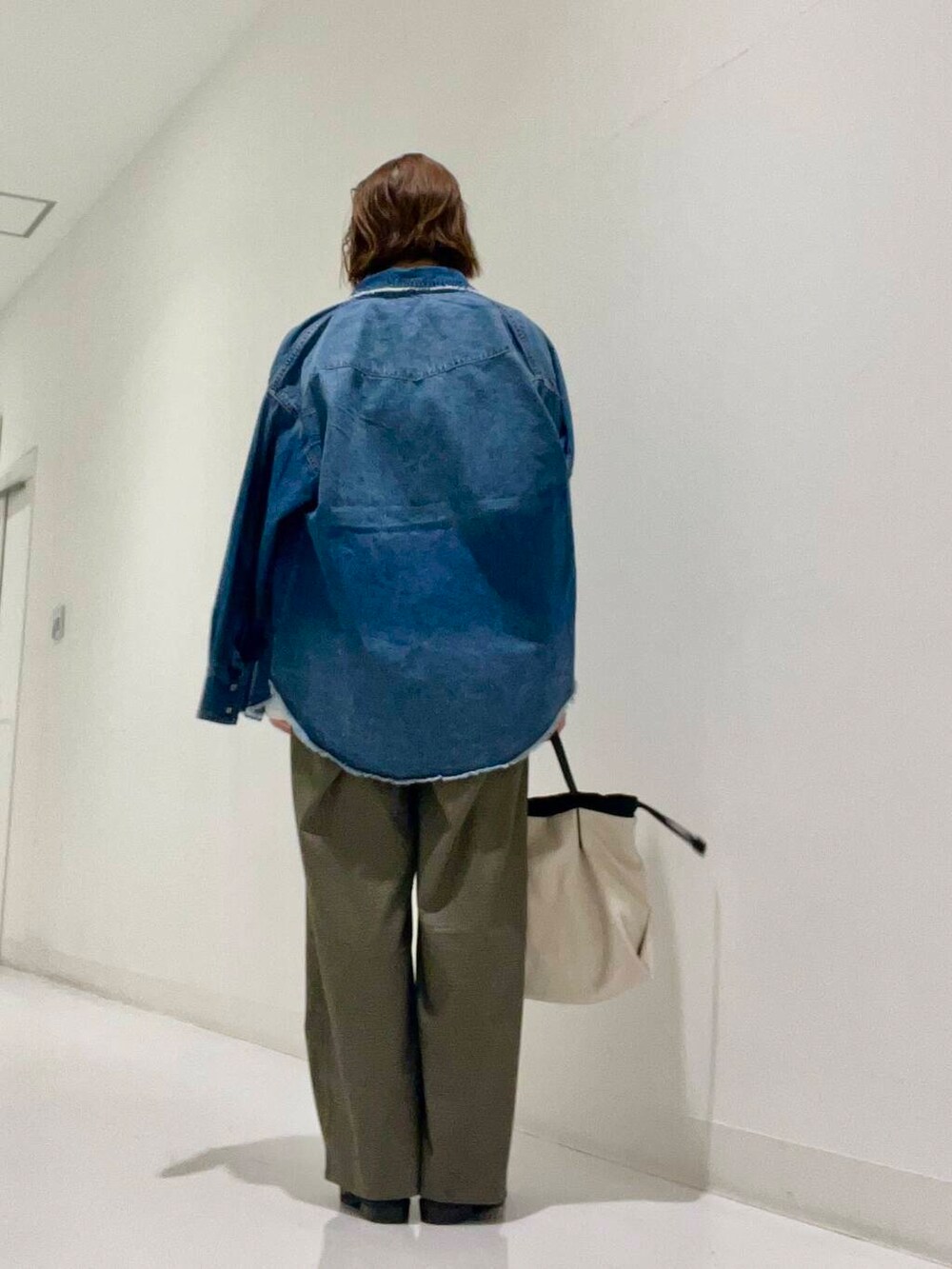 ホワイト系のショルダーバッグ、グレー系のブーツ、ブルー系のシャツ/ブラウスを着用したレディースの秋コーディネートの3枚目の写真