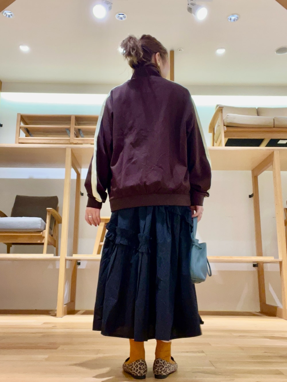 ブルー系のショルダーバッグ、ブラック系のスカート、レッド系のTシャツ/カットソーを着用したレディースの秋コーディネートの3枚目の写真