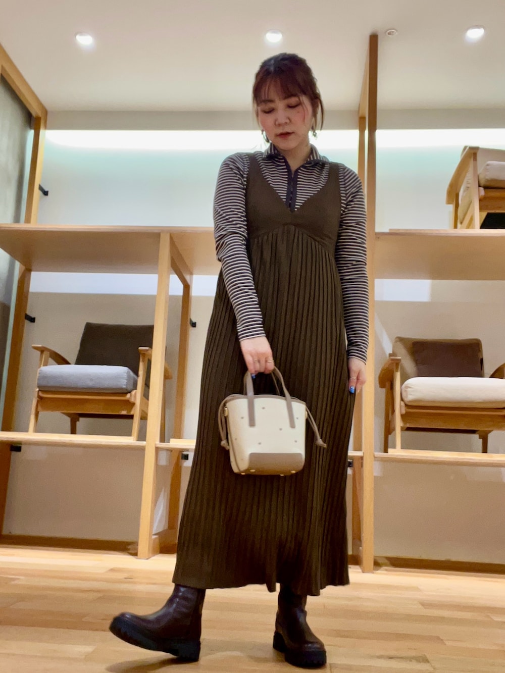 ブラック系のダウンジャケット/コート、ベージュ系のハンドバッグ、ブラウン系のワンピースを着用したレディースの秋コーディネートの5枚目の写真