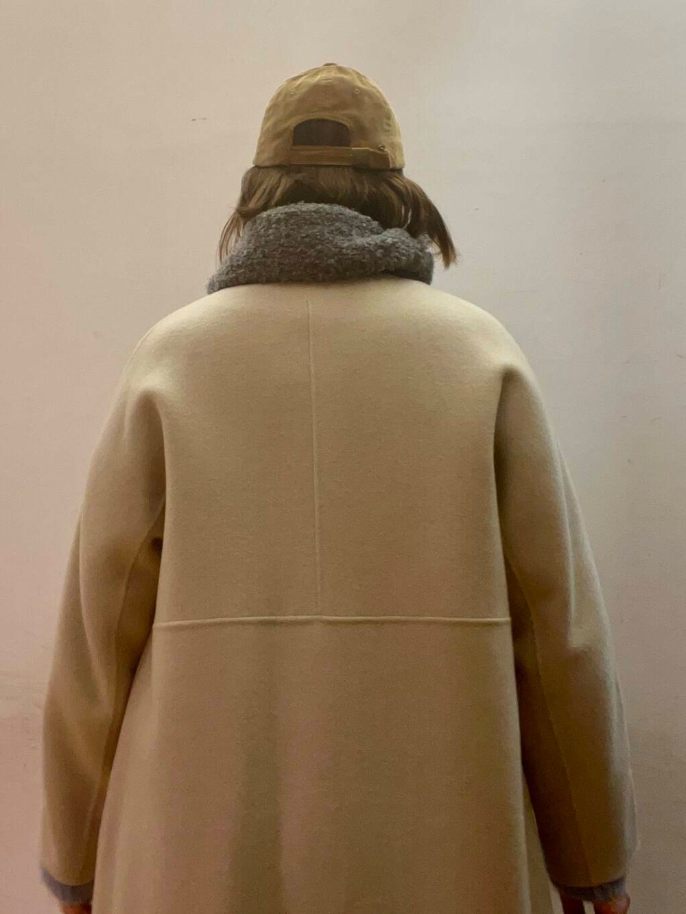 ベージュ系のステンカラーコート、シルバー系のブーツ、グレー系のワンピースを着用したレディースの冬コーディネートの5枚目の写真