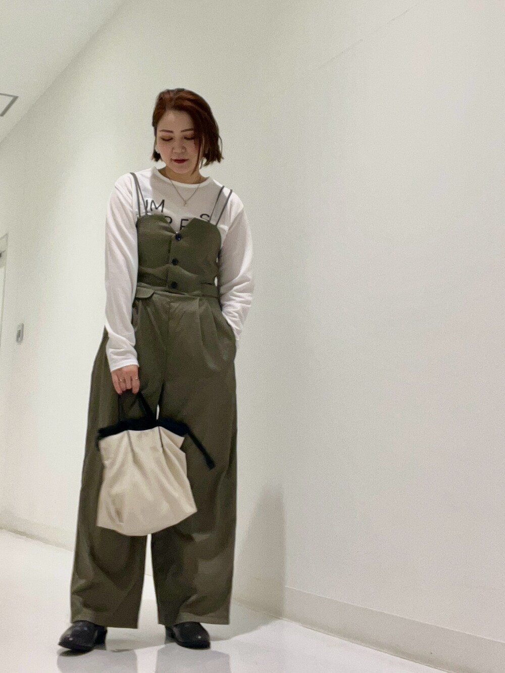 ブルー系のシャツ/ブラウス、ブラウン系のサロペット/オーバーオール、ホワイト系のトートバッグを着用したレディースの秋コーディネートの6枚目の写真