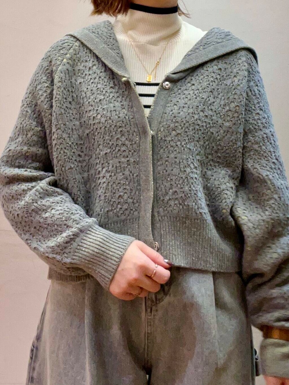 ブラック系のステンカラーコート、ホワイト系のニット/セーター、ブルー系のデニムパンツを着用したレディースの冬コーディネートの8枚目の写真