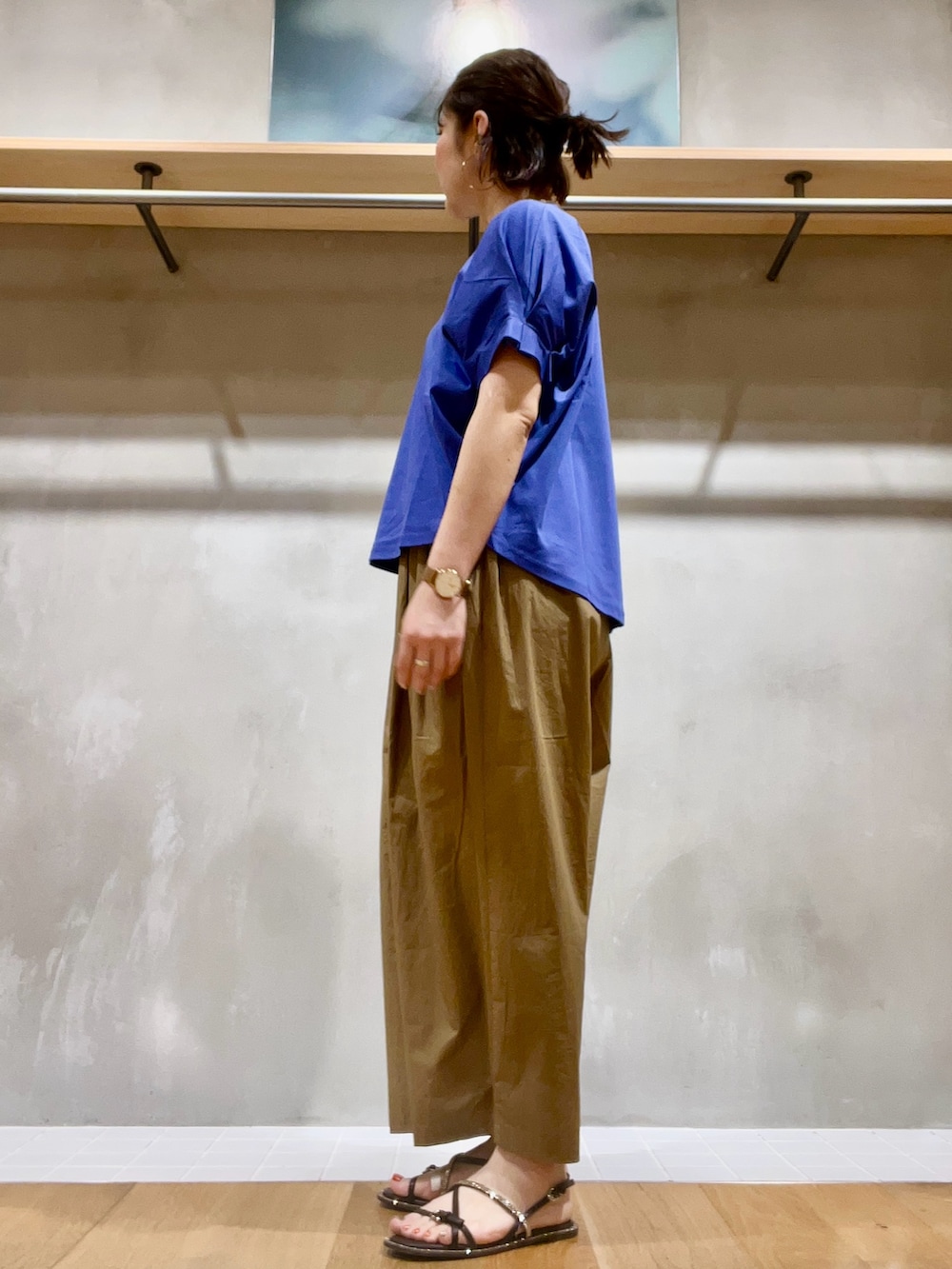 ブルー系のTシャツ/カットソー、ブラウン系のパンツ、ベージュ系のかごバッグを着用したレディースの夏コーディネートの3枚目の写真