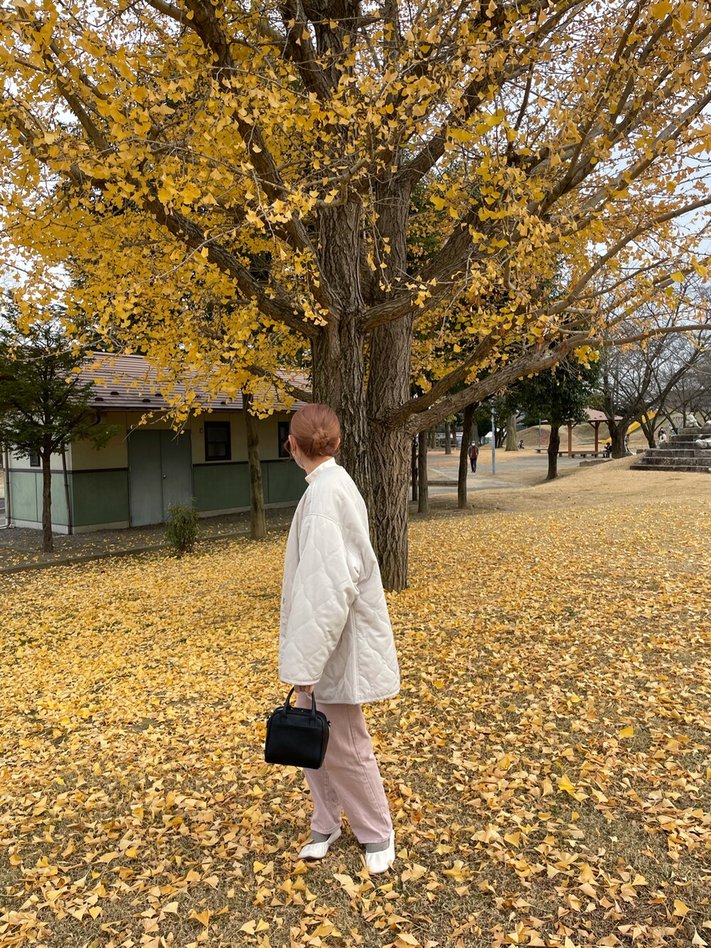 ホワイト系のノーカラージャケット、ピンク系のデニムパンツを着用したレディースの秋コーディネートの2枚目の写真