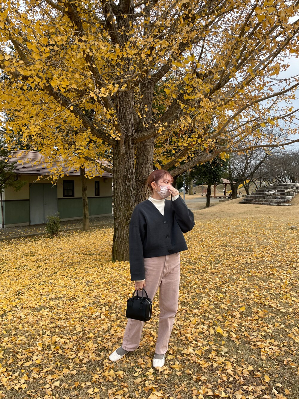 ホワイト系のノーカラージャケット、ピンク系のデニムパンツを着用したレディースの秋コーディネートの3枚目の写真