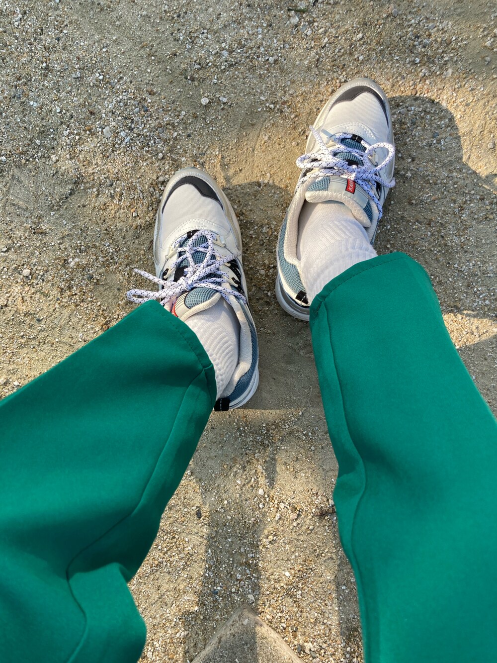 グリーン系のパンツ、ホワイト系のシャツ/ブラウス、その他のスニーカーを着用したレディースの春コーディネートの2枚目の写真