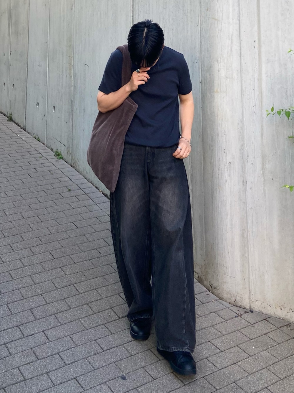 ブルー系のTシャツ/カットソー、ブラウン系のトートバッグ、ブラック系のデニムパンツを着用したメンズの夏コーディネートの2枚目の写真