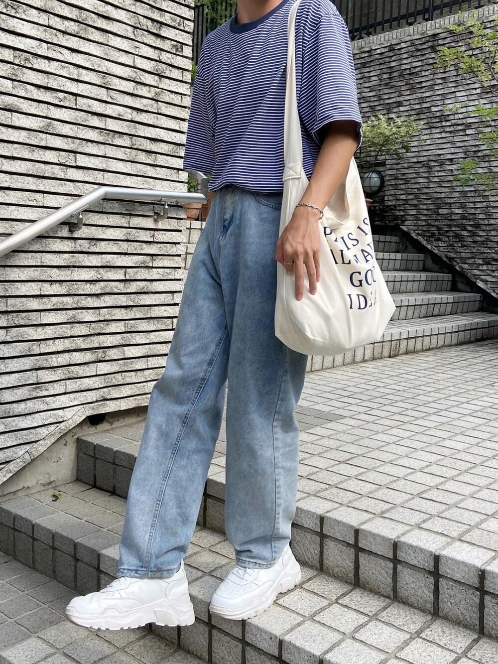 ブルー系のTシャツ/カットソー、ベージュ系のショルダーバッグ、ホワイト系のスニーカーを着用したメンズの夏コーディネートの3枚目の写真