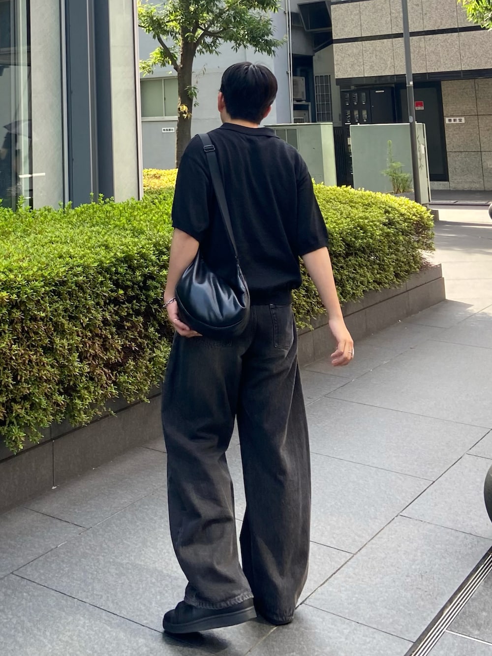 ブラック系のポロシャツ、ブラック系のデニムパンツを着用したメンズの夏コーディネートの3枚目の写真