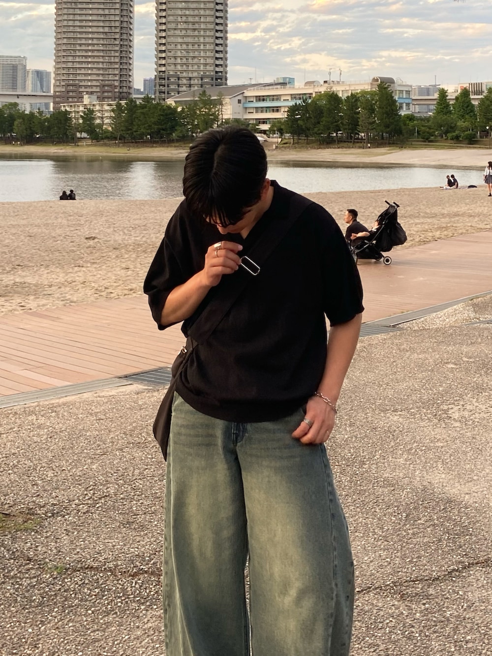 ブラック系のポロシャツ、グレー系のデニムパンツを着用したメンズの夏コーディネートの2枚目の写真