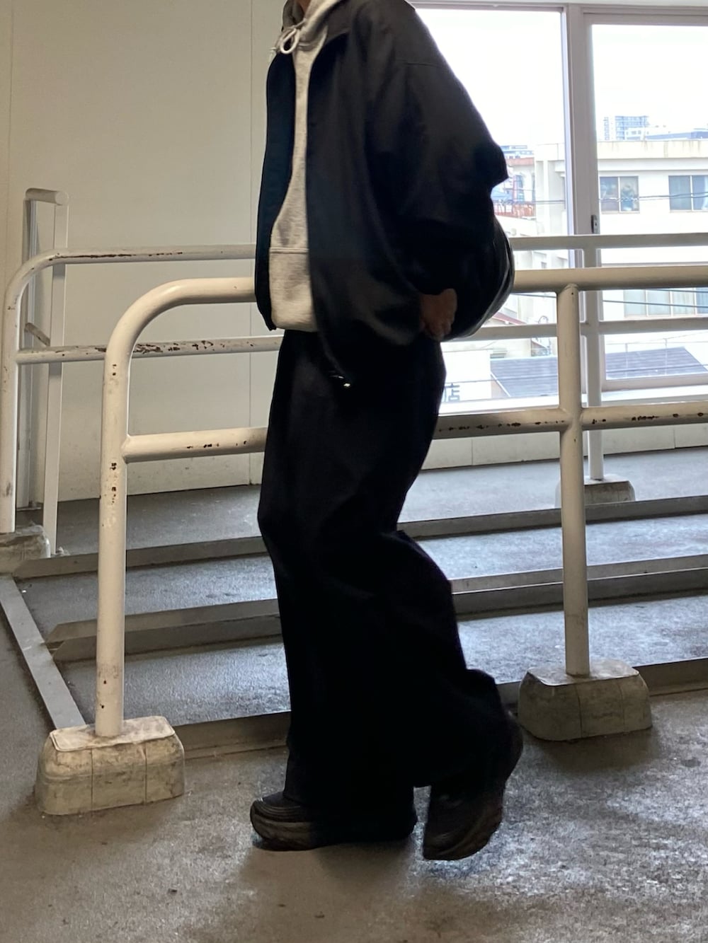 ブラック系のその他パンツ、ブラック系のスニーカー、ベージュ系のパーカーを着用したメンズの春コーディネートの2枚目の写真