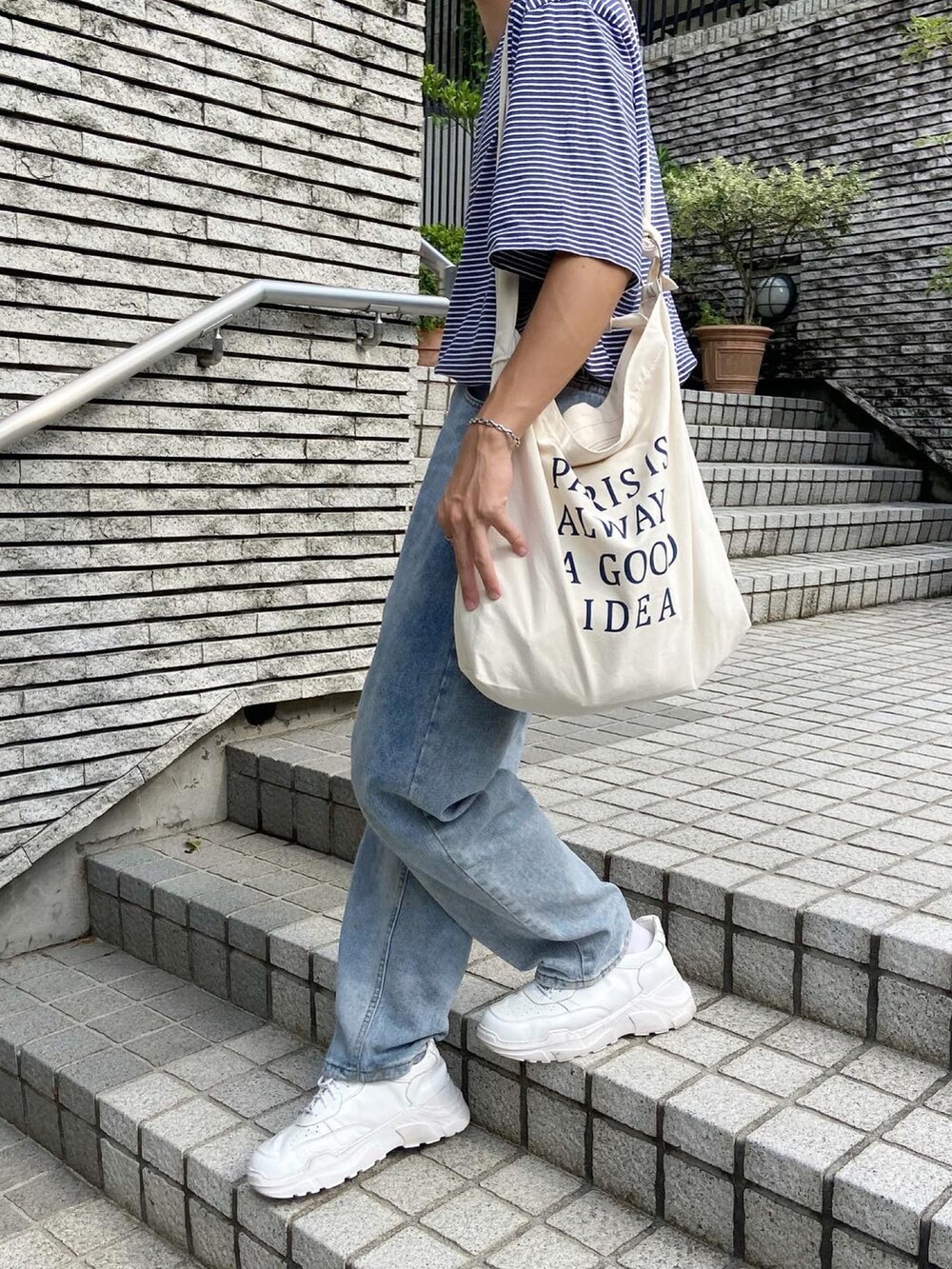 ブルー系のTシャツ/カットソー、ベージュ系のショルダーバッグ、ホワイト系のスニーカーを着用したメンズの夏コーディネートの2枚目の写真