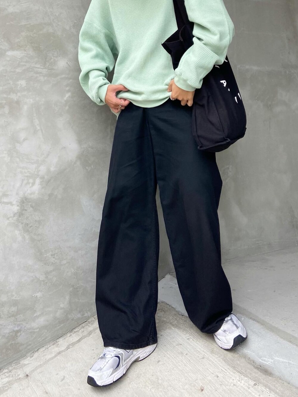 グリーン系のニット/セーター、ブラック系のトートバッグ、ブラック系のデニムパンツを着用したメンズの秋コーディネートの2枚目の写真