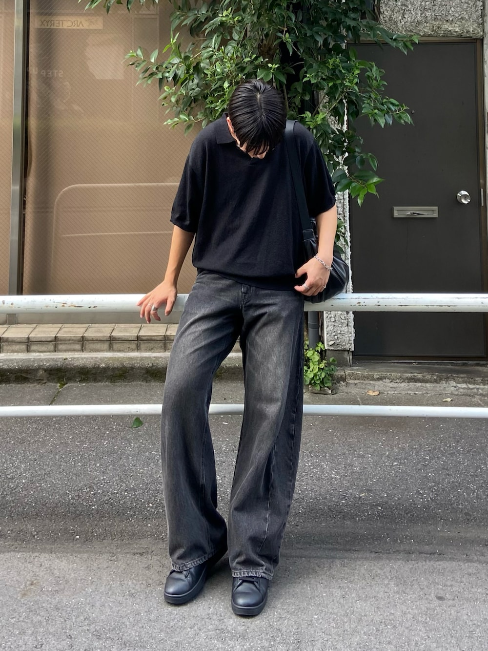 ブラック系のポロシャツ、ブラック系のデニムパンツを着用したメンズの夏コーディネートの2枚目の写真