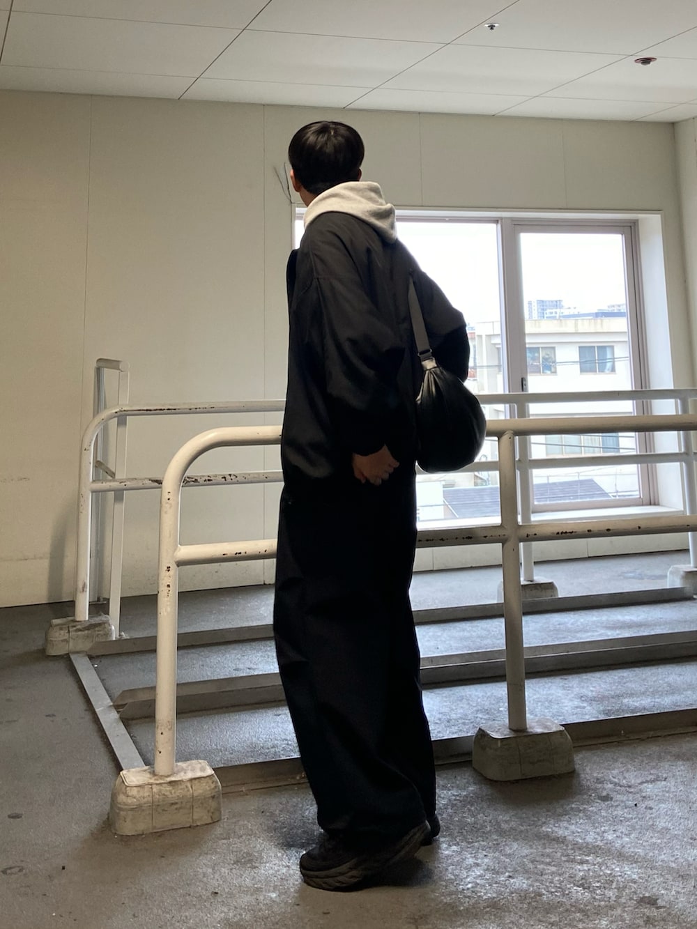 ブラック系のその他パンツ、ブラック系のスニーカー、ベージュ系のパーカーを着用したメンズの春コーディネートの3枚目の写真