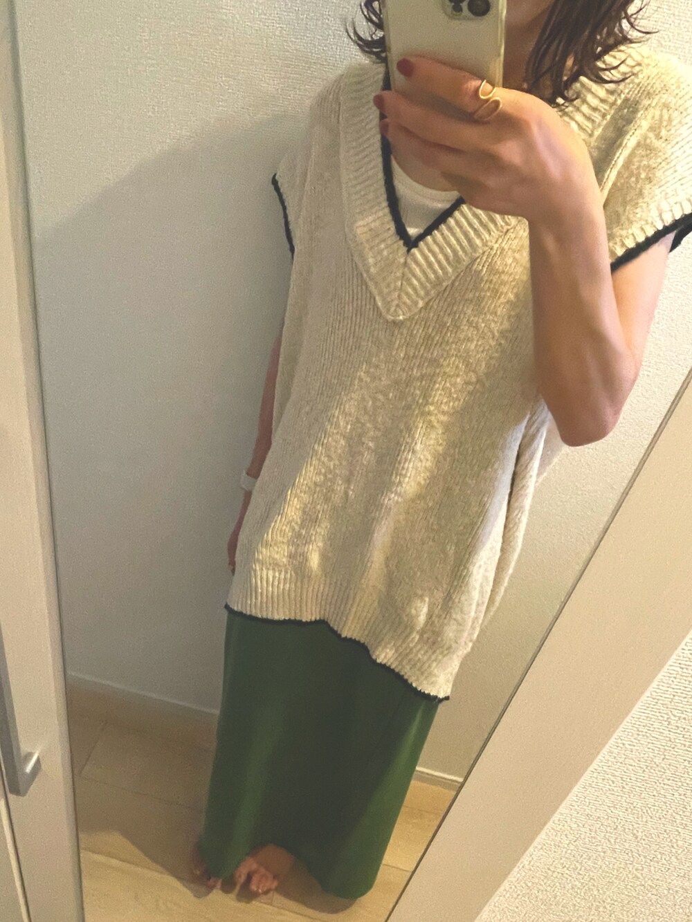 ベージュ系のベスト、グリーン系のスカートを着用したレディースの夏コーディネートの3枚目の写真