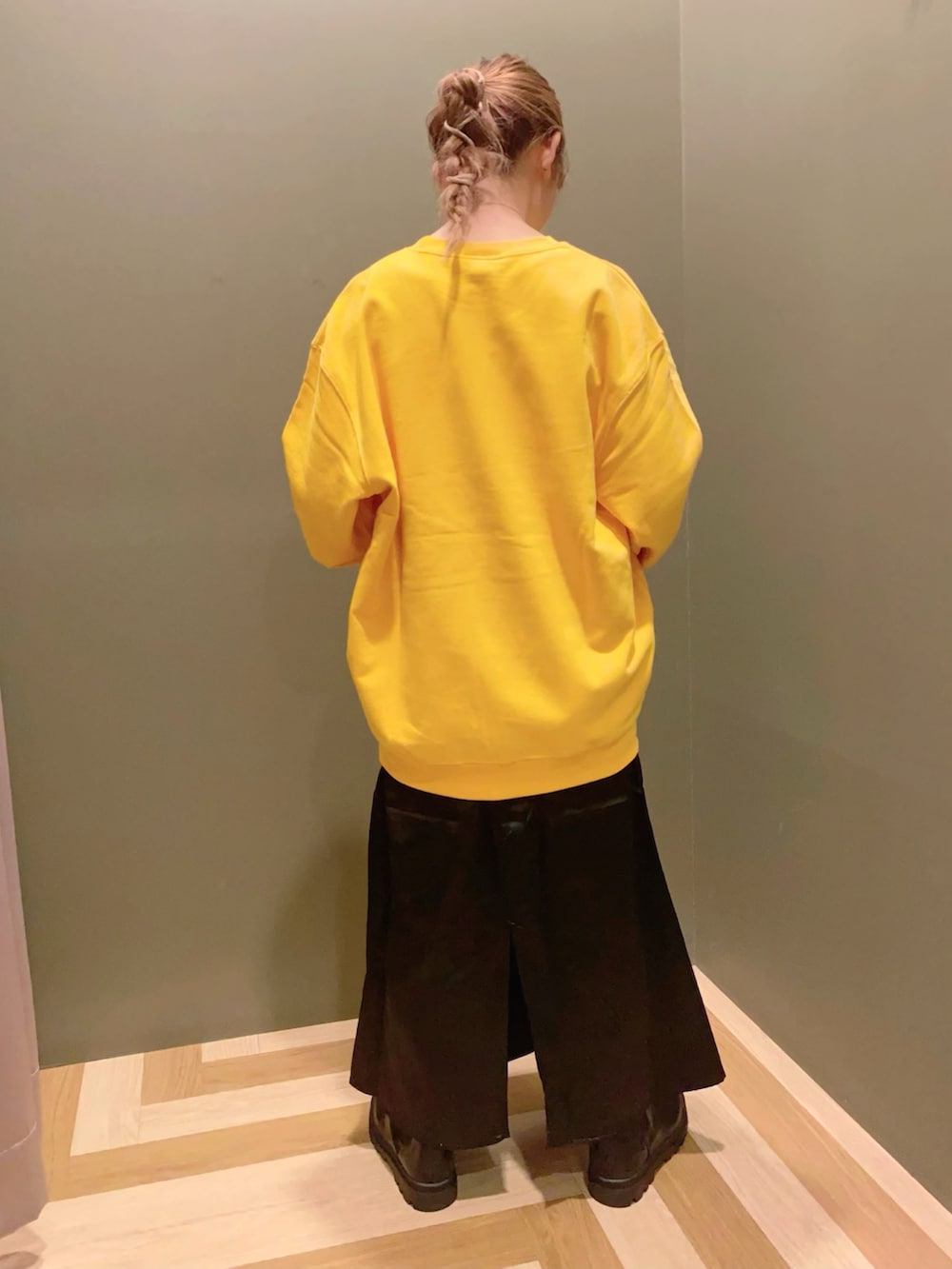 イエロー系のスウェット、ブラック系のスカート、ブラック系のシューズを着用したレディースの秋コーディネートの3枚目の写真