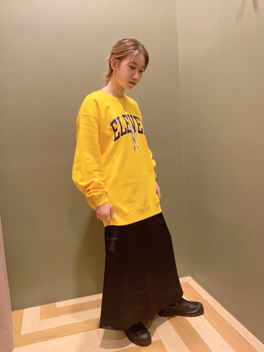 イエロー系のスウェット、ブラック系のスカート、ブラック系のシューズを着用したレディースの秋コーディネートの2枚目の写真