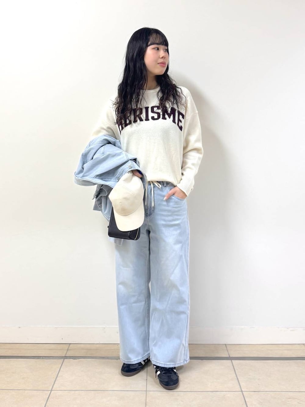 ホワイト系のニット/セーター、ブルー系のデニムパンツ、ブルー系のデニムジャケットを着用したレディースの冬コーディネートの2枚目の写真