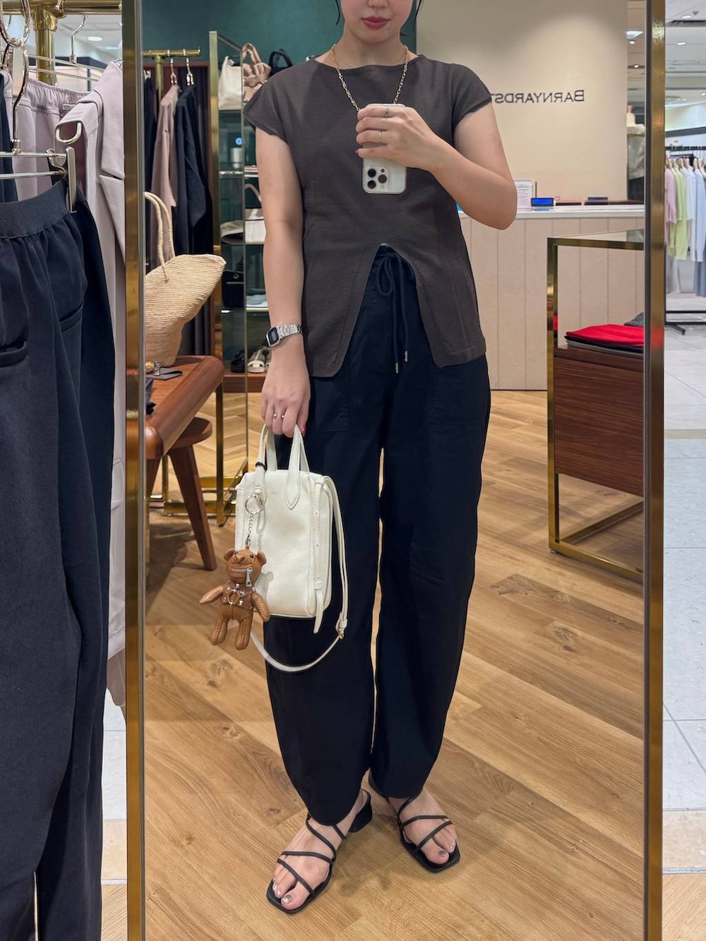 ホワイト系のショルダーバッグ、ブラック系のカーゴパンツ、ブラウン系のニット/セーターを着用したレディースの夏コーディネートの2枚目の写真