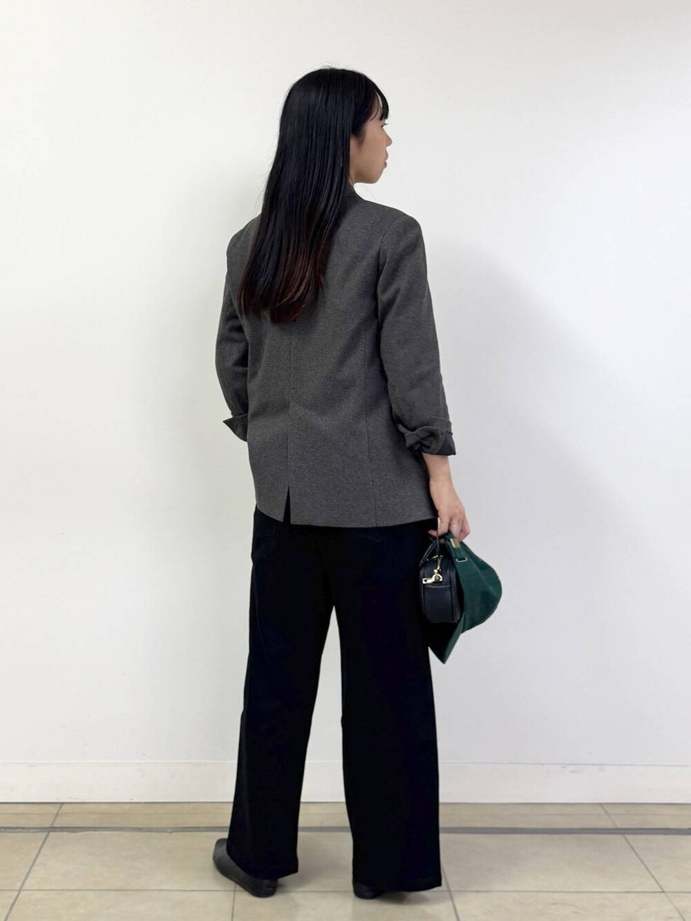 ブラック系のデニムパンツ、ブラウン系のテーラードジャケット、ブラック系のショルダーバッグを着用したレディースの秋コーディネートの3枚目の写真