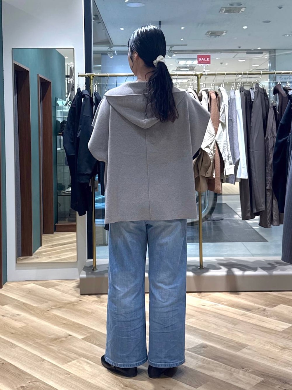 ブルー系のデニムパンツ、グレー系のベスト、ブラウン系のハンドバッグを着用したレディースの冬コーディネートの3枚目の写真