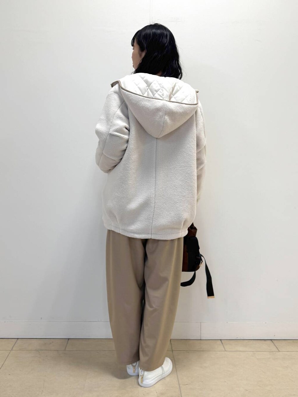 ブラウン系のニット/セーター、ホワイト系のその他アウター、ブラウン系のショルダーバッグを着用したレディースの冬コーディネートの3枚目の写真